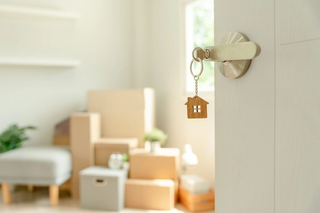 Door with house-shaped key, moving boxes visible.